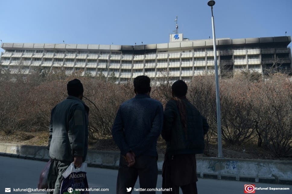 Des Afghans regardent l'hôtel Intercontinental à Kaboul le 22 janvier 2018 après une attaque menée par des talibans dans l'établissement qui a fait au moins 22 morts